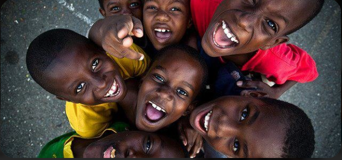 Children laughing and reaching toward the camera with joy and hope