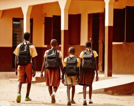Students in uniform walking toward school with backpacks